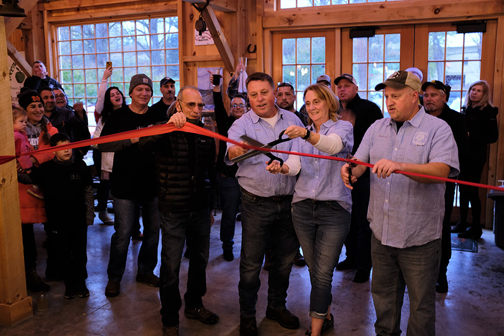 Marlborough Supervisor Al Lanzetta [l.] held the ribbon as it was being cut by Peggy Kent, with the assistance of her husband Chip and brother-in-law James, to officially open the new Locust Grove Brewing Company.